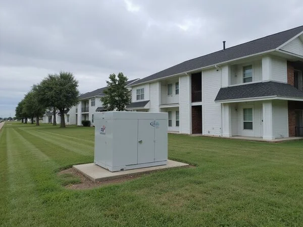 Standby generator beside a new apartment building