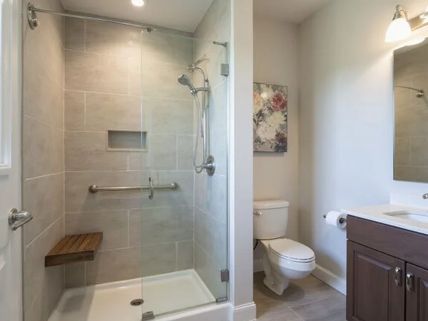 Walk-in shower with a grab bar in a new apartment